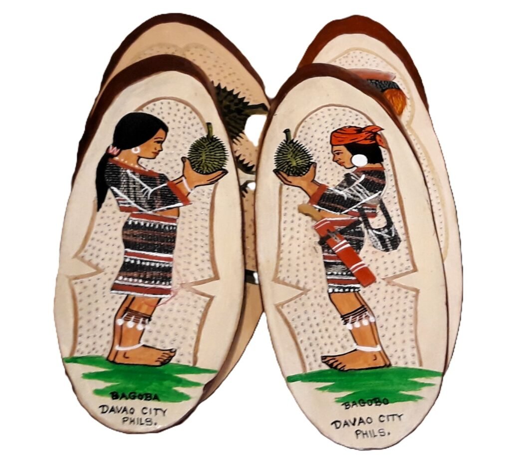 Souvenirs from Davao. A girl and a boy in national outfit holding durian.